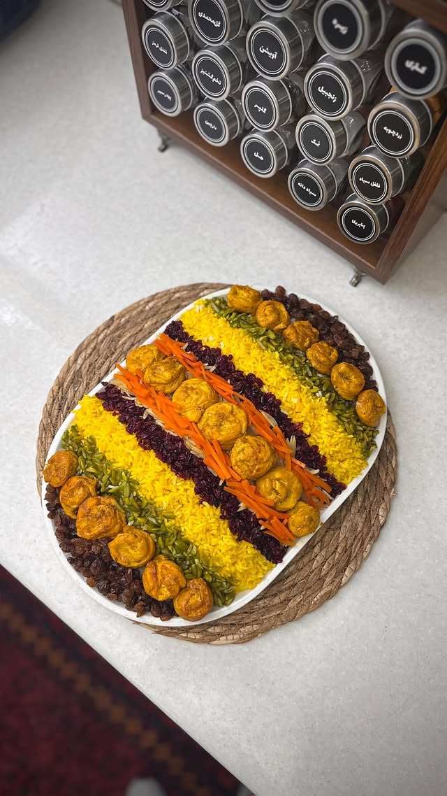 کسی‌هست این غذارو دوست نداشته‌باشه؟🫣این جا ادویه ای کاربردی رو از باکس شاپ گرفتم که تولید و طراحی خودشون هست و انواع جا ادویه ای و جا حبوباتی چوبی وارداتی هم دارن✅😍@box_shop_home @box_shop_home (( در ضمن پرداخـ.ت ۲تا۳مرحله ای هم دارن))📍مرصع پلو:🍗سینه مرغ رو نواری برش بزنید و رول کنیدو به خلال چوبی بزنید، طبق ویدیو بچینید روی پیاز و بهش زعفران و سیر و ادویه ی پاپریکا و فلفل سیاه و نمک و روغن اضافه کنید؛ درب تابه رو بزارید با حرارت ملایم مرغ ها بپزه و ابش که جمع شد بزارید کمی سرخ بشه.خلال پسته و خلال بادوم رو با گلاب نیم ساعت بخیسونید و بعد توی کره تفت بدید، زرشک و کشمش رو هم با کره تفت بدید، هویج خلالی رو هم با زعفرون و کمی شکر و کره تفت بدید.(خلال پوست پرتقال هم نیاز داره که من نزاشتم)....#مرصع_پلو #غذای_ایرانی #هویج_پلو #دیزاین_غذا by @imarylife