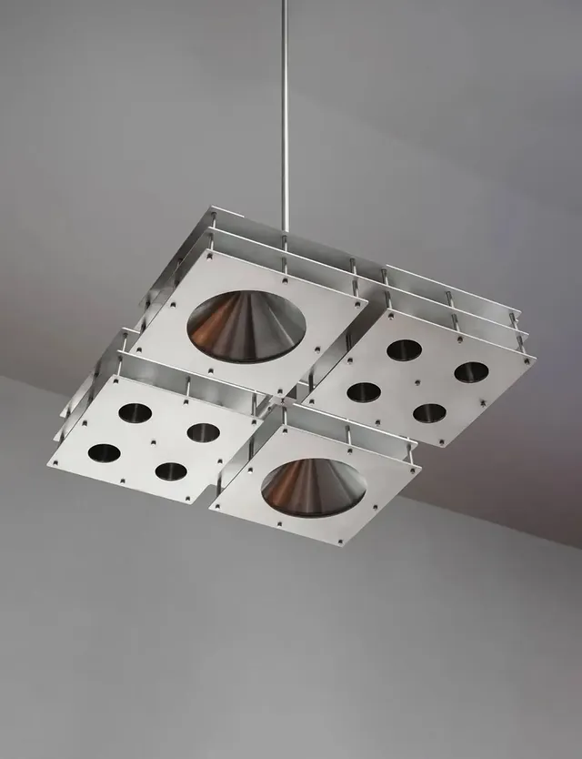 Steel does not usually set a mood but this one does.Designed by @___.dpt for Nightcall bar, this ceiling piece is built from brushed aluminium panels joined by exposed rods, housing conical downlights that shift color and rhythm throughout the night. It is a functional object first. Four modular squares, precise joinery, industrial in material and method.But programmed light changes what an object is. The same fixture reads differently at midnight than it does at opening.The bar does not need art on the walls. The ceiling is enough.🎥 @evg.baranova#LightingDesign #InteriorArchitecture #AmbientLight #HospitalityDesign #BarDesign by @designplusmag