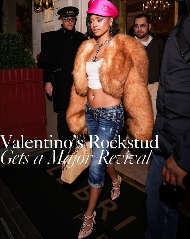 Every fashion era has its defining shoe, and for much of the 2010s, it was @MaisonValentino’s Rockstud. First unveiled on the house’s Fall/Winter 2010 runway by then-co-creative directors #MariaGraziaChiuri and #PierpaoloPiccioli, the design quickly became one of the decade’s most recognizable accessories. Defined by delicate straps traced with signature metal studs, the Rockstud balanced romance with a rebellious edge, while matching handbags carried the same hardware-lined appeal. Arriving at a moment when fashion was oscillating between indie sleaze’s after-dark glamour and a renewed embrace of bohemian femininity, the style struck an immediate chord with consumers. While fashion’s aesthetic priorities evolved throughout the late 2010s and early 2020s, the Rockstud retained its status as a modern classic. Now, as nostalgia-fueled dressing and statement accessories return to the forefront, Valentino’s iconic studded silhouette feels especially relevant once again. Visit the link in our bio to read more on the trend. Photos Getty Images and Valentino #valentinorockstuds #valentino #tyla dakotajohnson
